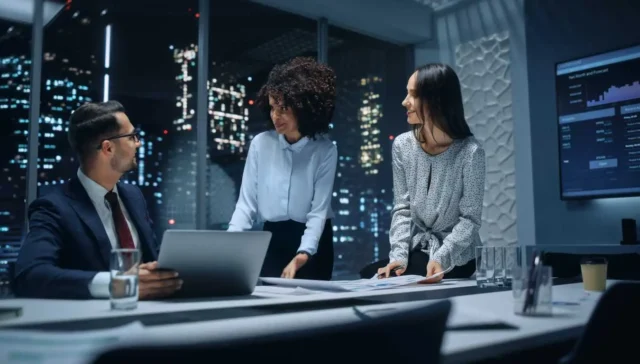 Office Conference Room Meeting: Diverse Team of Top Managers Talk, Brainstorm, Use Laptop Computer. Business Partners Discuss Financial Reports, Plan Operations Based on Line and Pie Graph Reports.