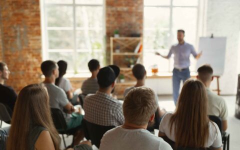 Male speaker giving presentation in hall at university workshop