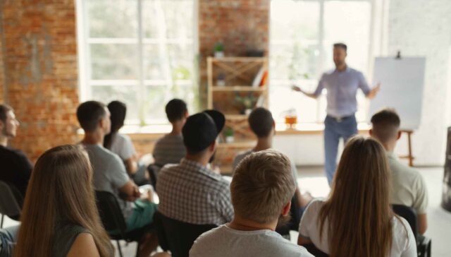 Male speaker giving presentation in hall at university workshop