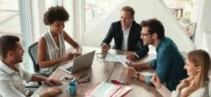 office management talking and laughing on something on a meeting table