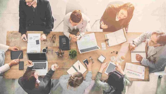 Team sitting together on a table rounded and discuss on something
