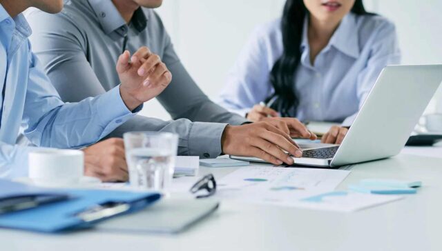 Collague sitting together and watching something important in laptop