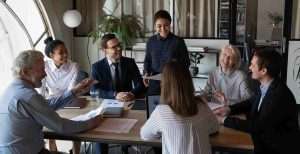 employees sitting together around the table and laugh