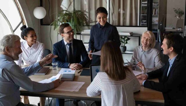 employees sitting together around the table and laugh