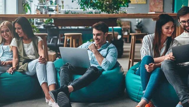 collague siting together on bean bag and working on laptop