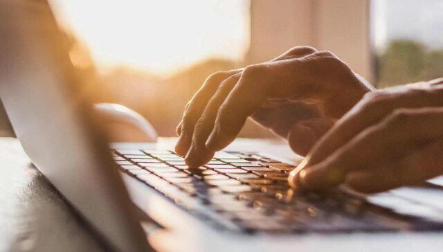two hand typing something on laptop