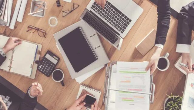 IT employees working on a office table with their accessories