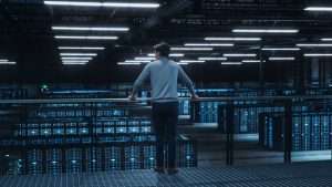 Data Center Engineer Looking Down from a Balcony on Server Farm Cloud Computing Specialist Facility. Multiethnic Asian System Administrator Working with Data Protection Network for Cyber Security