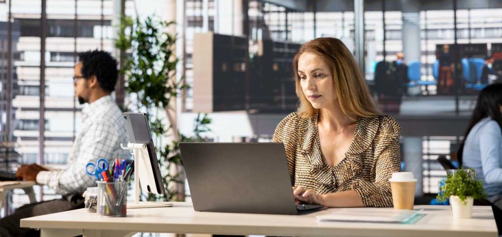 Professional company executive reviews enterprise solutions on her laptop